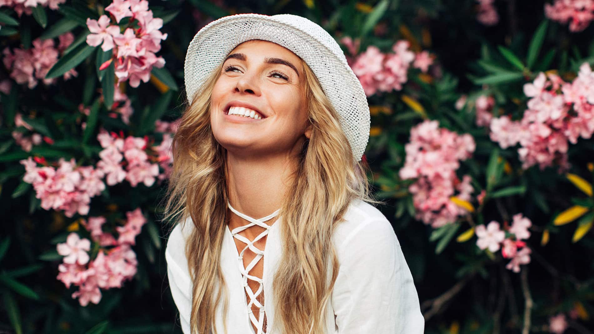 Vrouw die lacht tegen bloemenachtergrond