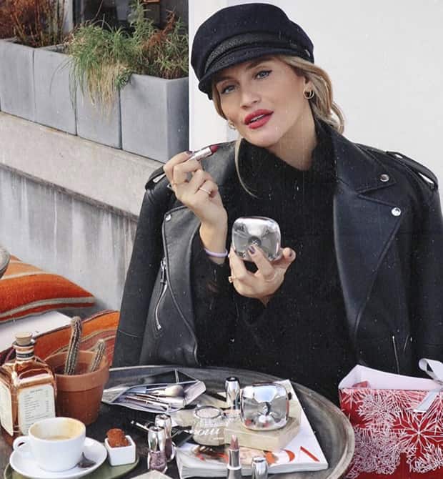 Lima Ché zit op terras en doet lippenstift op