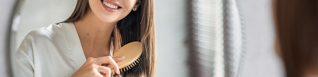 vrouw-borstelt-haar-haircare-routine-na-de-zomer