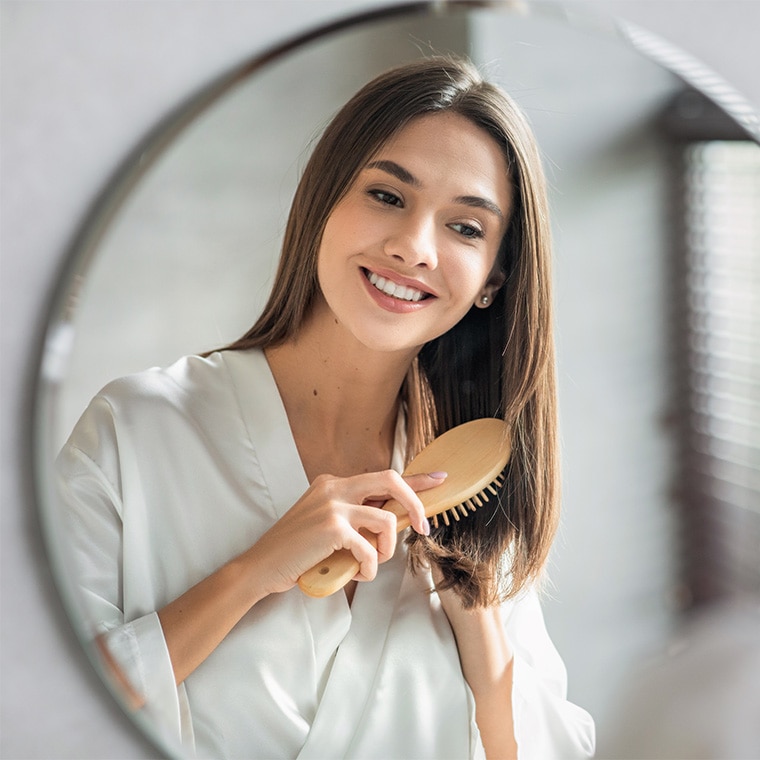 vrouw-borstelt-haar-haircare-routine-na-de-zomer