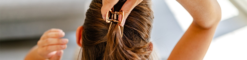 Vrouw met bruine haren draagt een haarspeld. 