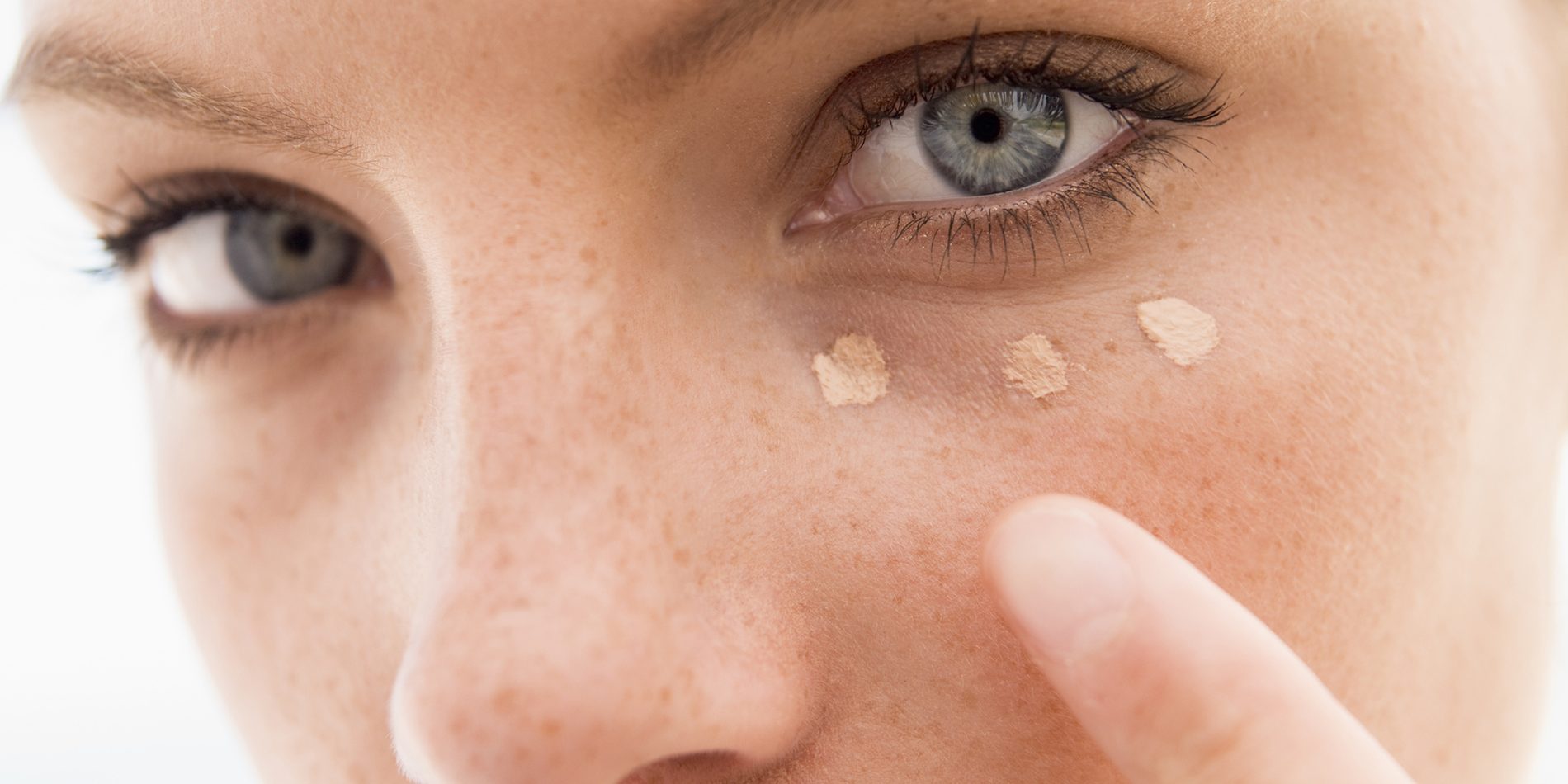 Woman applying concealer