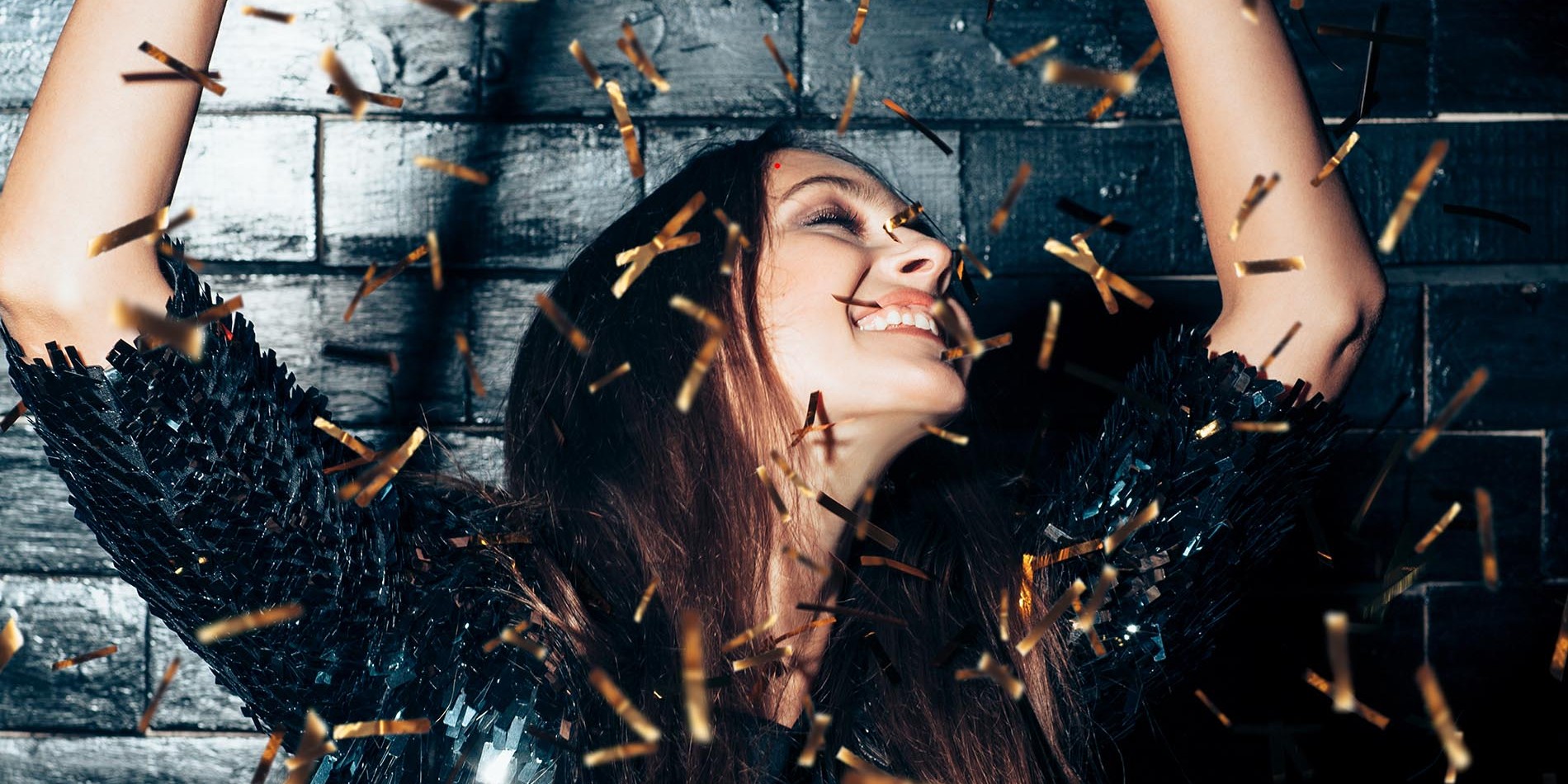 Young beautiful woman dancing in confetti and enjoying party. Happiness. New year, Birthday, Holiday Event concept