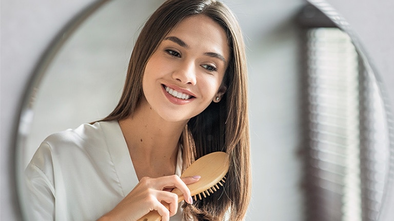 Vrouw met bruine haren doet haar haircare routine. Vrouw met bruine haren doet haar haircare routine.