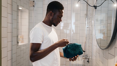 Homme avec trousse de toilette dans la salle de bain						 Homme avec trousse de toilette dans la salle de bain
